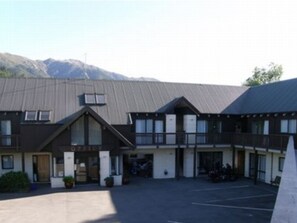 A building with a sloped roof, multiple windows, and a parking lot.