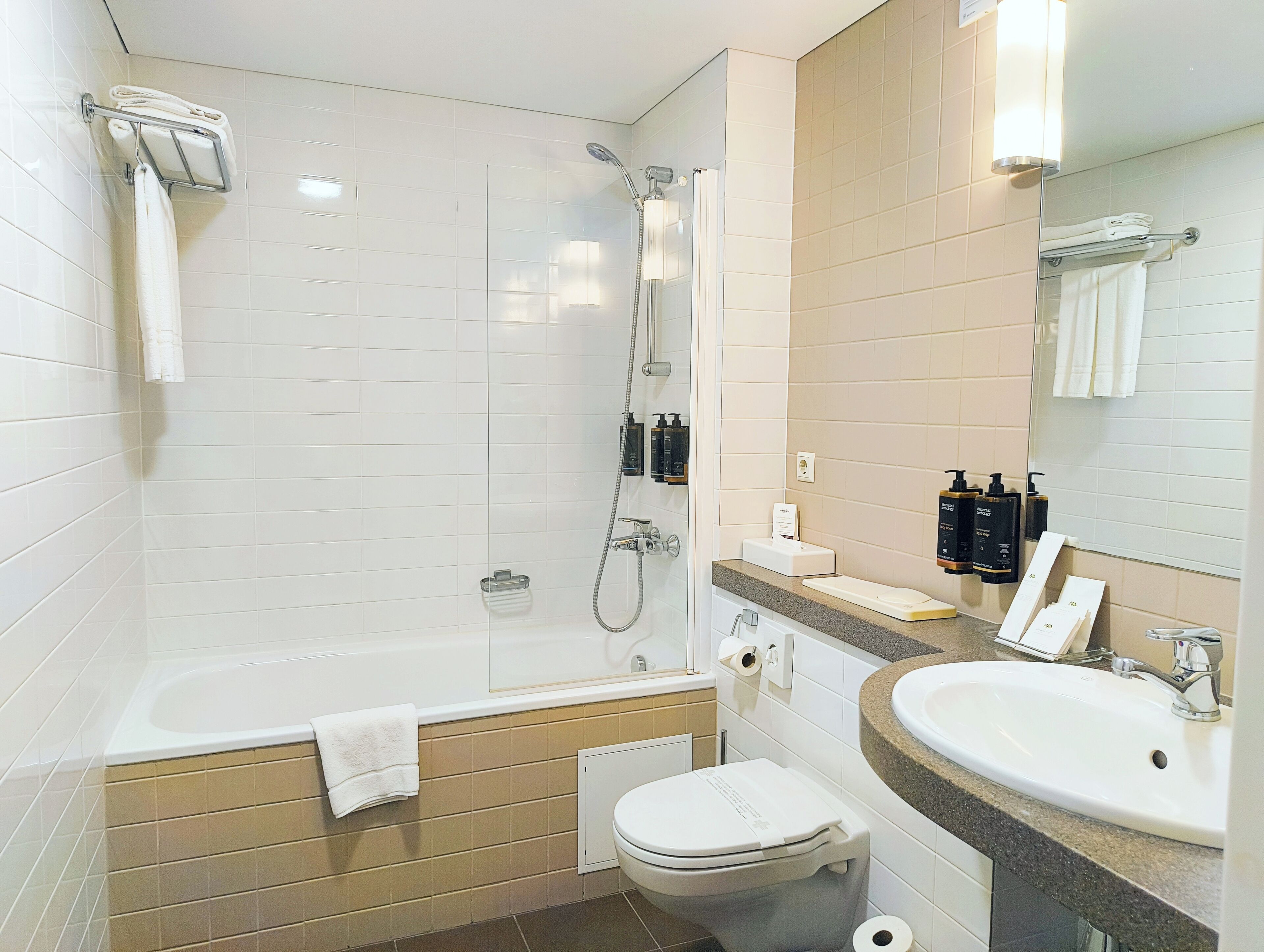 A modern bathroom with a bathtub, toilet, and sink.