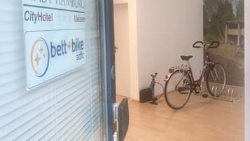 Interior de un hotel con un cartel de Stadt Hamburg, CityHotel, y publicidad de bicicletas con correa.