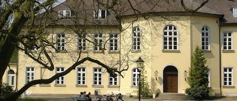 A large, yellow building with multiple windows and a central entrance.