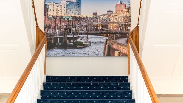 A staircase with a cityscape view including a bridge and a boat.