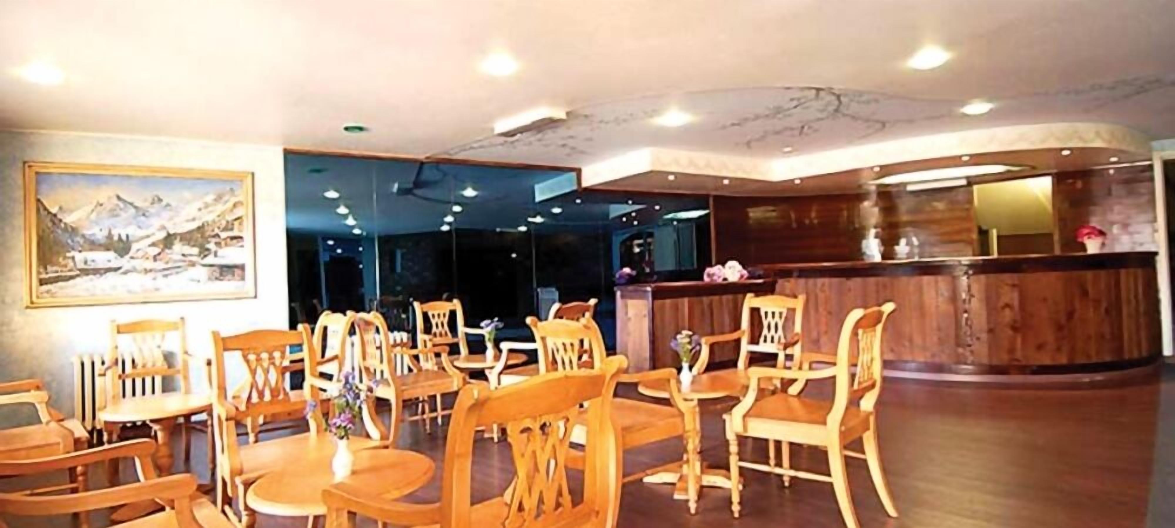 Um restaurante com mobiliário de madeira, um balcão de recepção e um quadro na parede.
