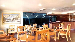 Un restaurante con mobiliario de madera, una mesa de recepción y un cuadro en la pared.
