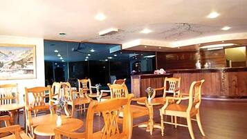 Um restaurante com mobiliário de madeira, um balcão de recepção e um quadro na parede.
