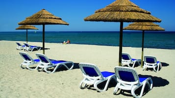 PÄ stranden, vit sandstrand, solstolar och vattenskidÄkning