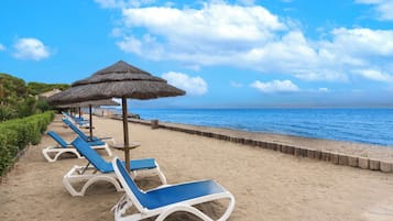 On the beach, white sand, sun loungers, water skiing