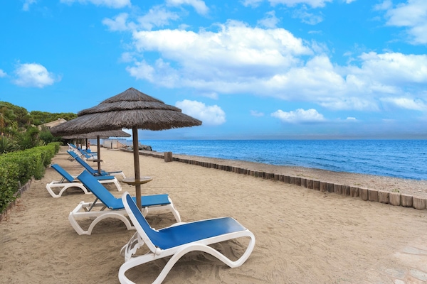 On the beach, white sand, sun loungers, water skiing