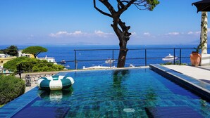 A clear blue swimming pool with a tree in the center, a view of the sea, and a lifeguard stand. - Villa Marina Capri - Preferred Hotels & Resorts (Capri)