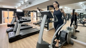 Un gimnasio con cintas de correr, elípticas y máquinas de pesas.