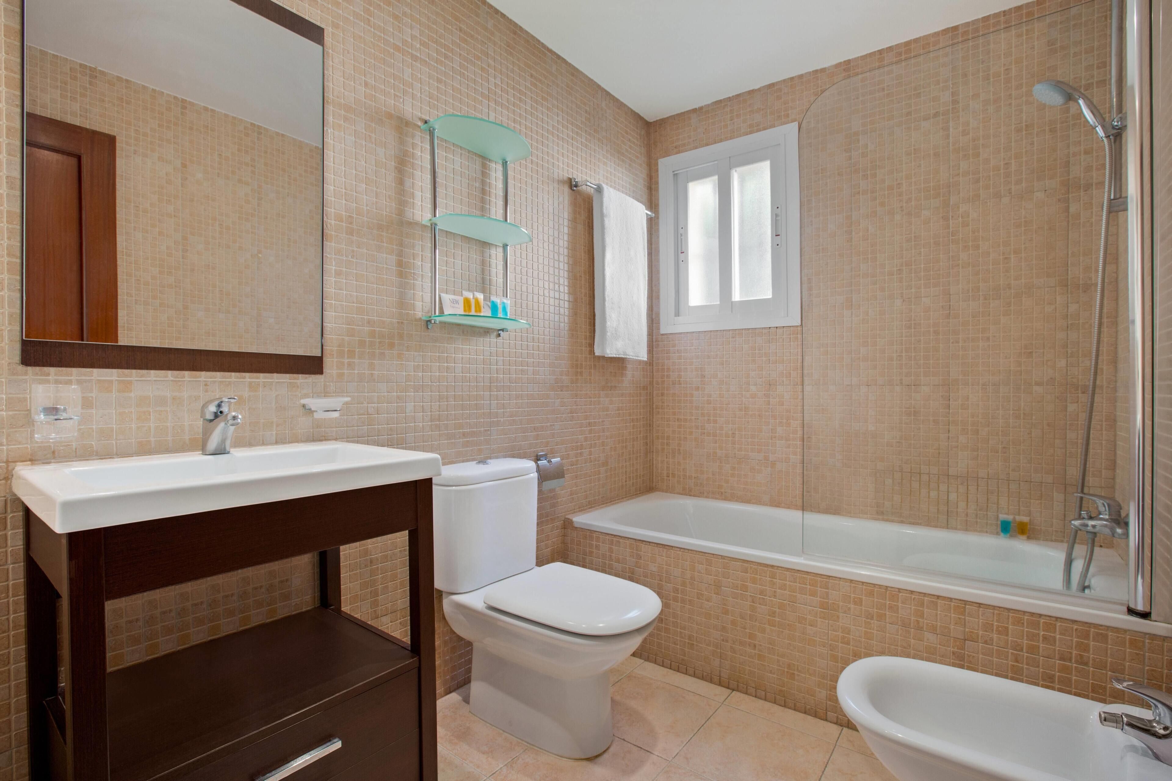 A bathroom with a sink, toilet, bathtub, and shower.