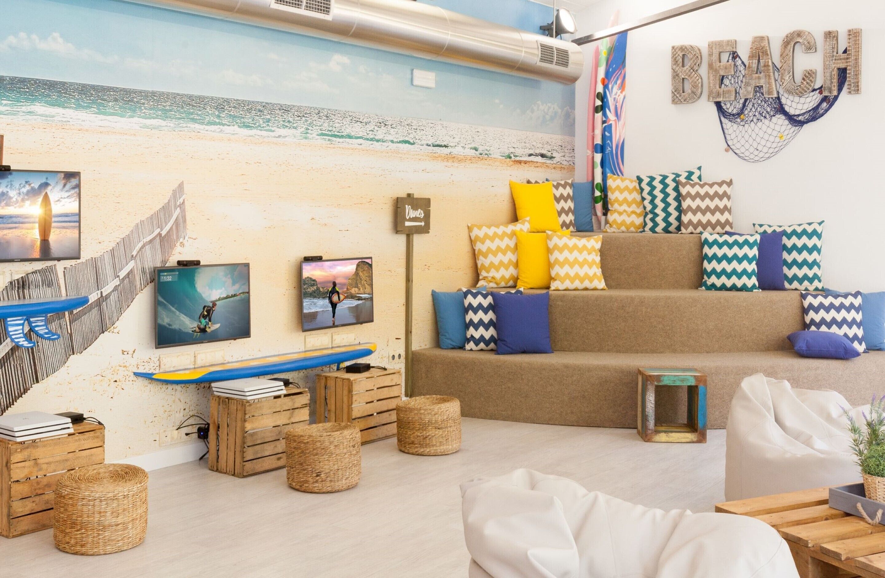A beach-themed room with a mural, surfboard, and beach-themed pillows.