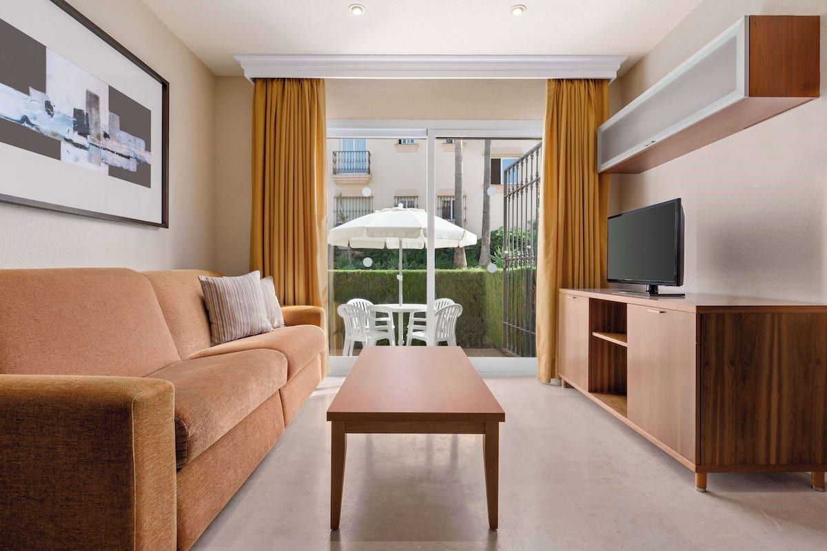 Premium Apartment, 1 Bedroom | Living area | 32-inch LCD TV with satellite channels, books