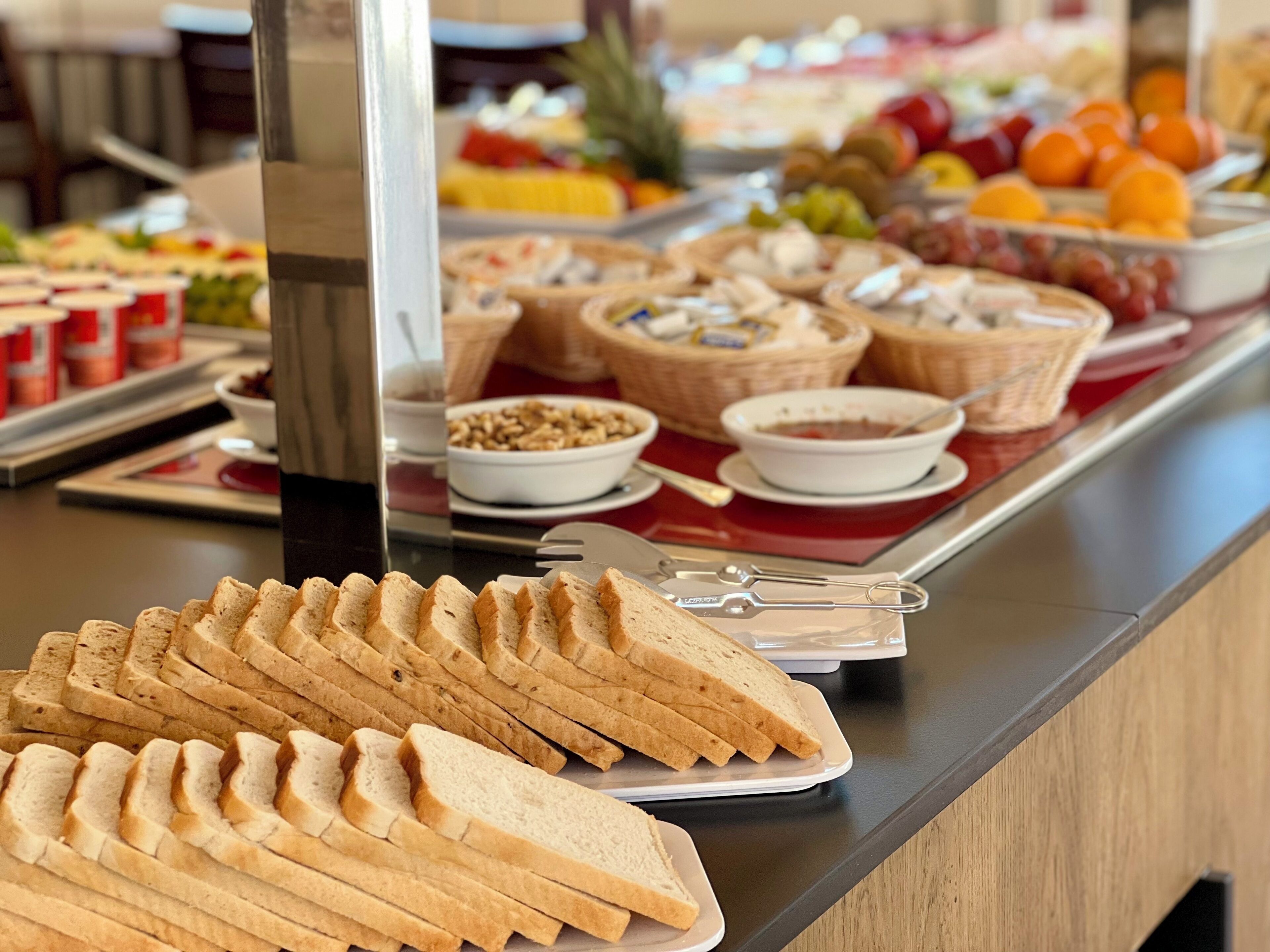 En buffé med ett varierat utbud av mat, inklusive bröd, frukt och desserter.