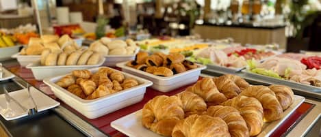 A buffet with various food items including pastries and salads.