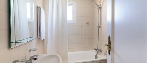 A bathroom with a sink, toilet, bathtub, and shower.