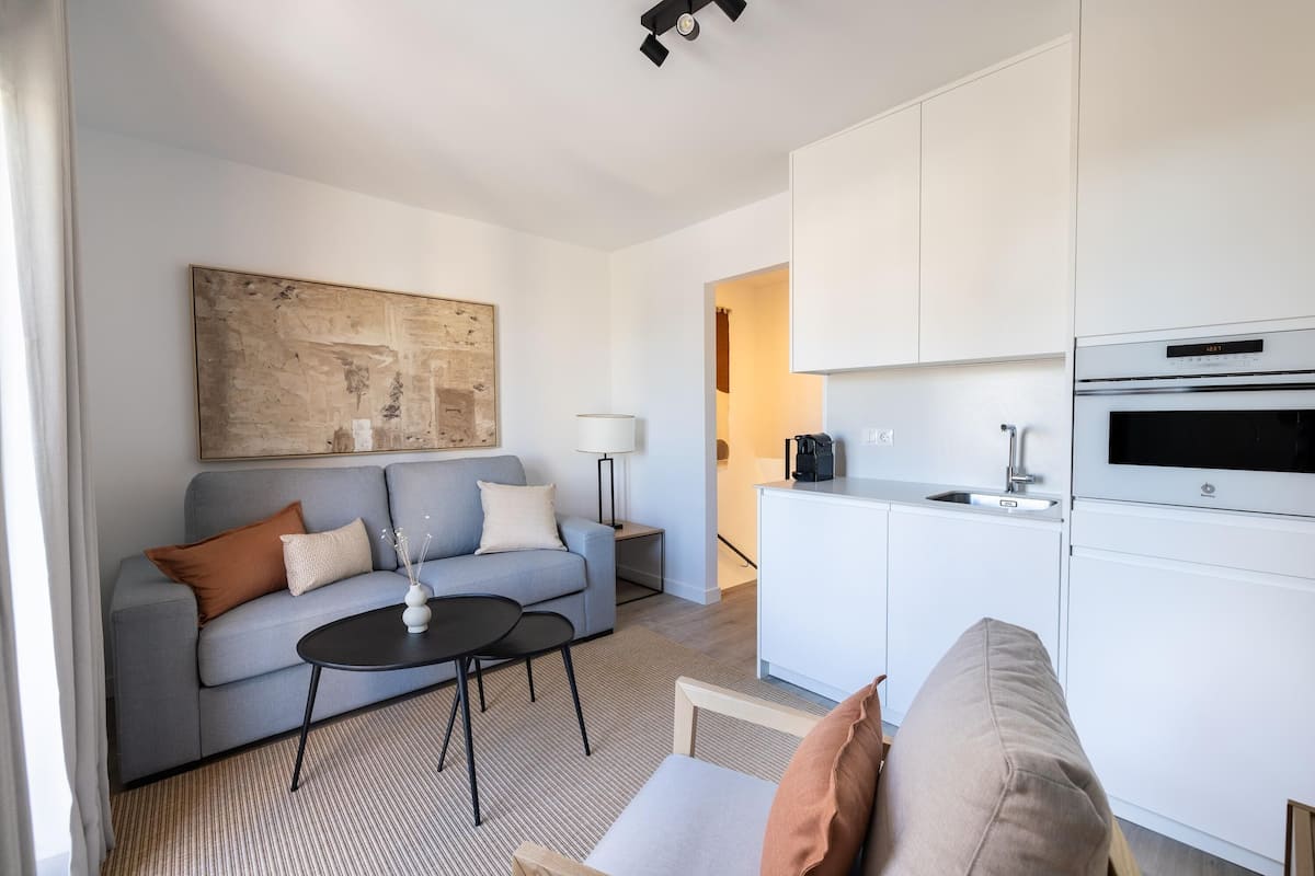 Un saló modern amb un sofà, una taula de centre i un quadre a la paret.