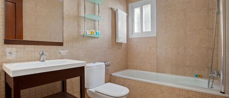 Un baño con inodoro, lavamanos, bañera y ducha.