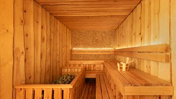 Een houten sauna met banken en een stenen muur.