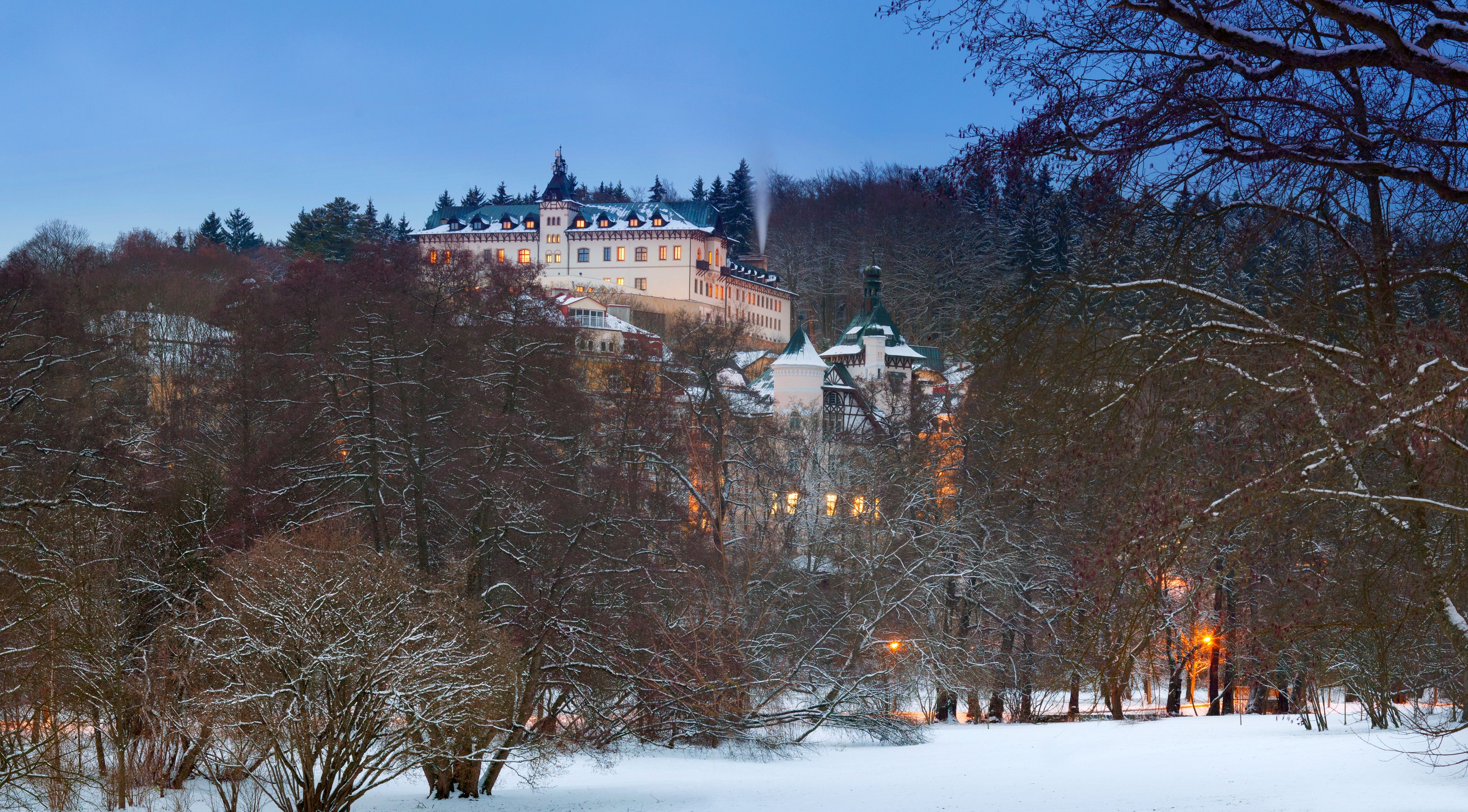 A large, historic building with multiple towers and a snow-covered landscape.