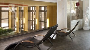 Un espace intérieur vaste, doté d’un haut plafond, de grandes fenêtres et d’un coin salon avec des fauteuils en osier.