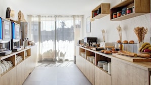 Una cocina moderna con armarios de madera, una cafetera y una variedad de productos horneados a la vista.