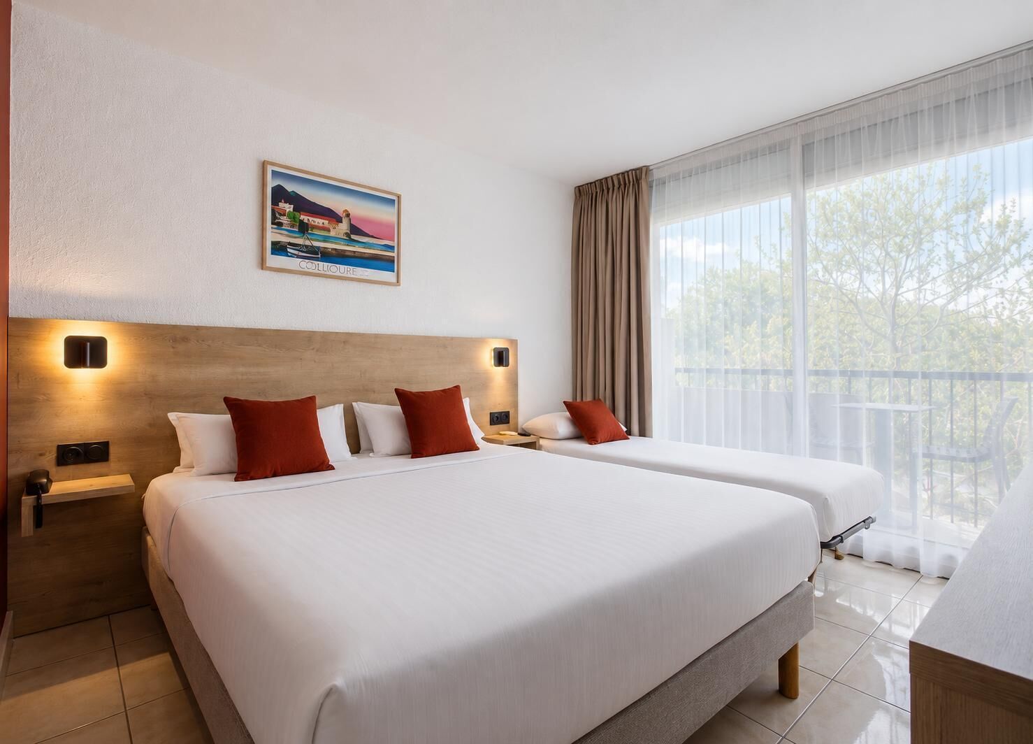 Habitación de hotel con dos camas, un ventanal con cortinas, un cuadro en la pared y un balcón.