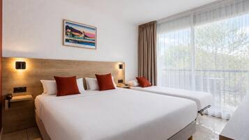 Habitación de hotel con dos camas, un ventanal con cortinas, un cuadro en la pared y un balcón.