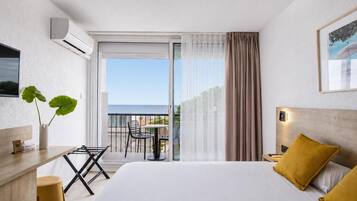 Habitación doble superior, vista al mar | Minibar, caja de seguridad en la habitación y escritorio