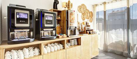 Una estación de café con varias máquinas de café y una variedad de tazas y platillos.