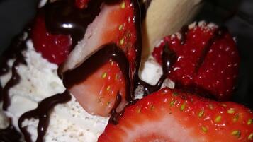 Een dessert met aardbeien, slagroom en chocoladesaus.