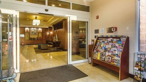 Un hall de hotel con mostrador de recepción, zona de estar y exhibición de revistas.