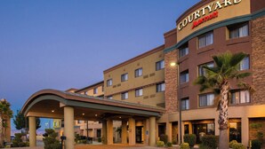 A Courtyard Marriott hotel with a covered entrance, multiple floors, and a palm tree in the foreground.