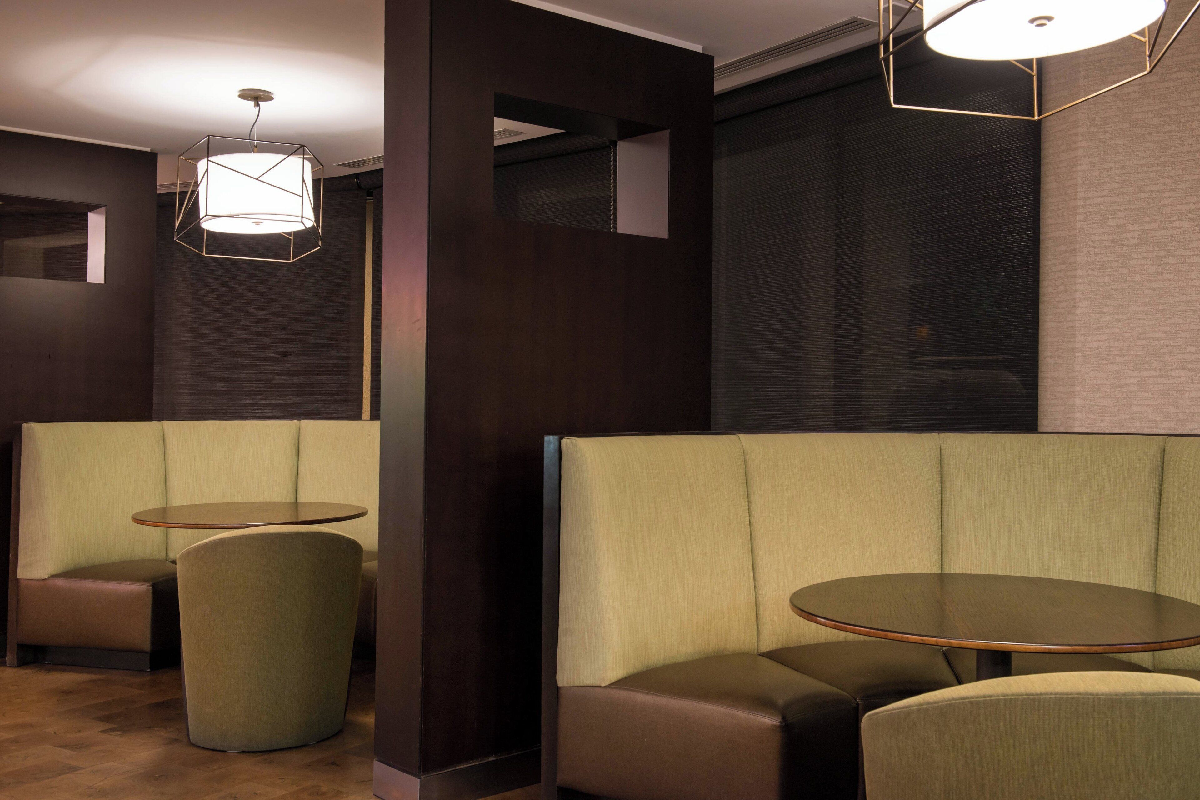 A modern interior with seating arrangements, including booths and a round table.