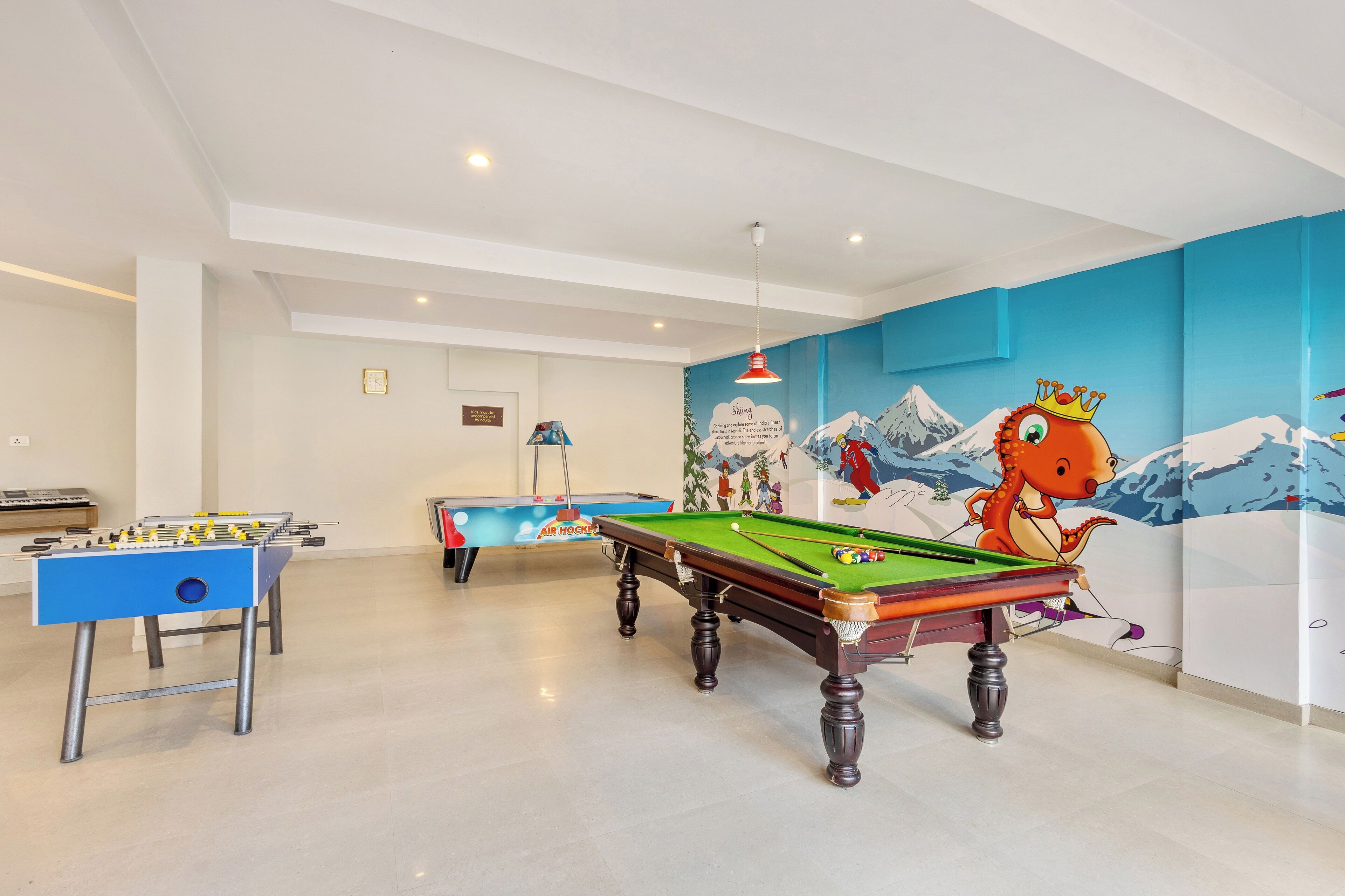 Una habitación con mesa de billar, mesa de futbolín y mesa de billares.