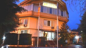A hotel with a prominent 'HOTEL' sign, a second-floor balcony, and a well-lit entrance. - Aristocrat Hotel (Skopje)