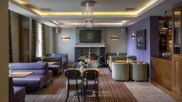 Ein moderner Lounge-Bereich mit Sitzgelegenheiten, Kamin und Bar.