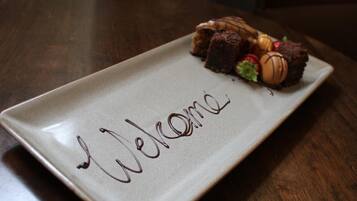Un plato rectangular con la palabra 'Welcome' escrita en chocolate sobre una superficie color beige.