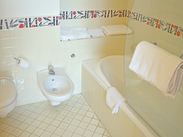 Un baño con bidé, lavamanos y bañera.