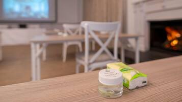 A room with a wooden table, a bottle of hand sanitizer, and a box of tissues.