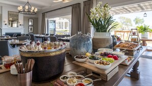 A buffet setup with various food items and a large ice bucket.