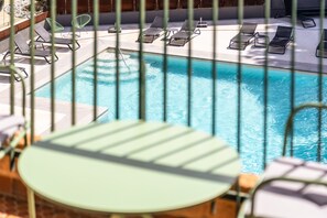 Relax by the pool surrounded by comfortable lounge chairs and umbrellas.