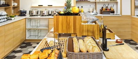 Montaje de buffet con pan, bollería y frutas.
