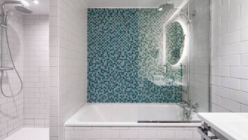 A modern bathroom with a bathtub, shower, and a tiled wall.