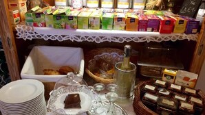 Un bufé de desayuno con diversas opciones de comida, como pasteles, pan y salsas.