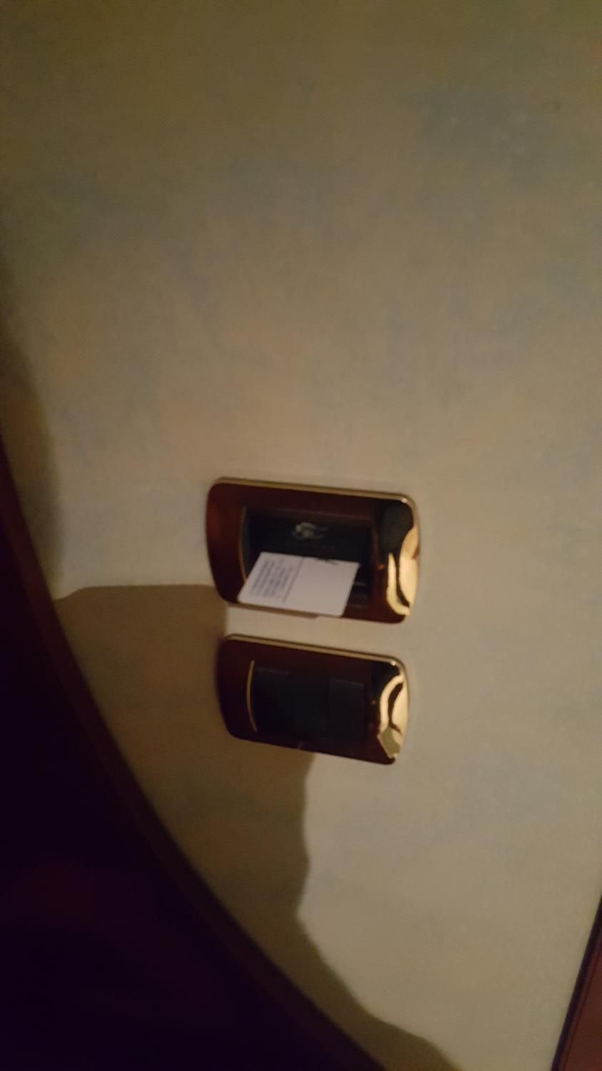 En lukket, metallisk genstand med en etiket, placeret på en beige overflade.