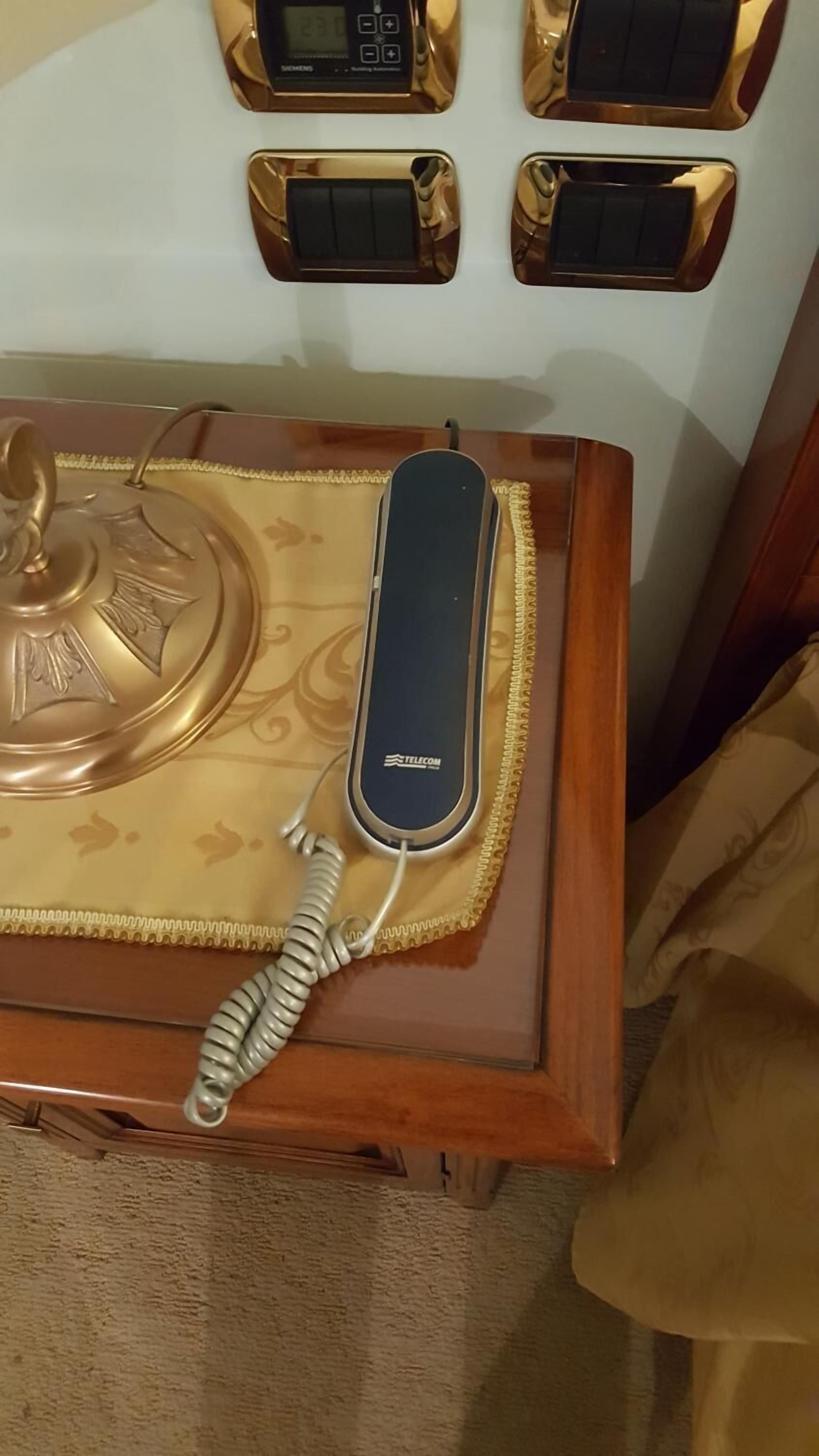 Un telefono d'epoca su un tavolo di legno con un decoro.