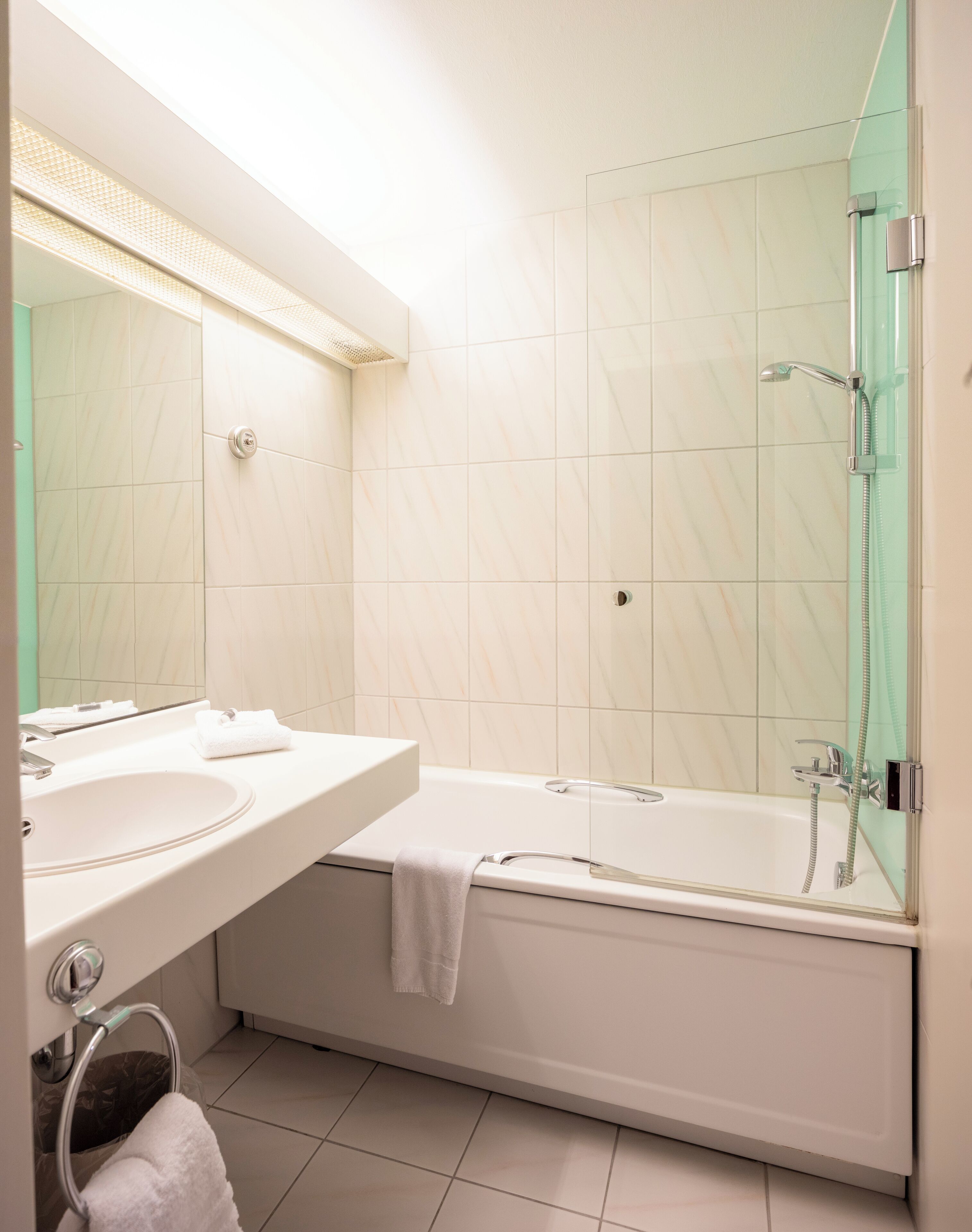 A modern bathroom with a sink, mirror, and a glass-enclosed shower.