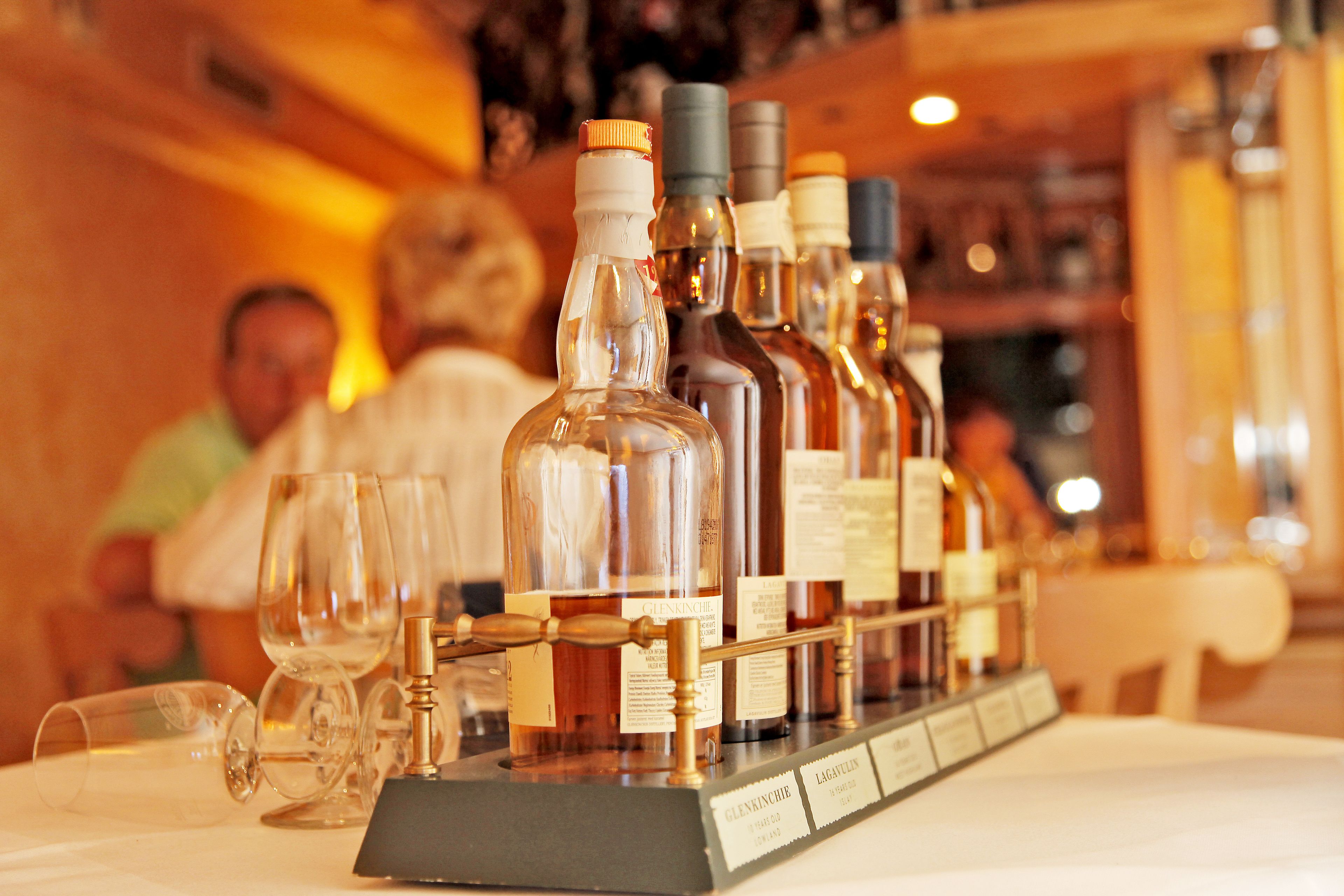 A selection of wine bottles on a display table with glasses and a menu stand.