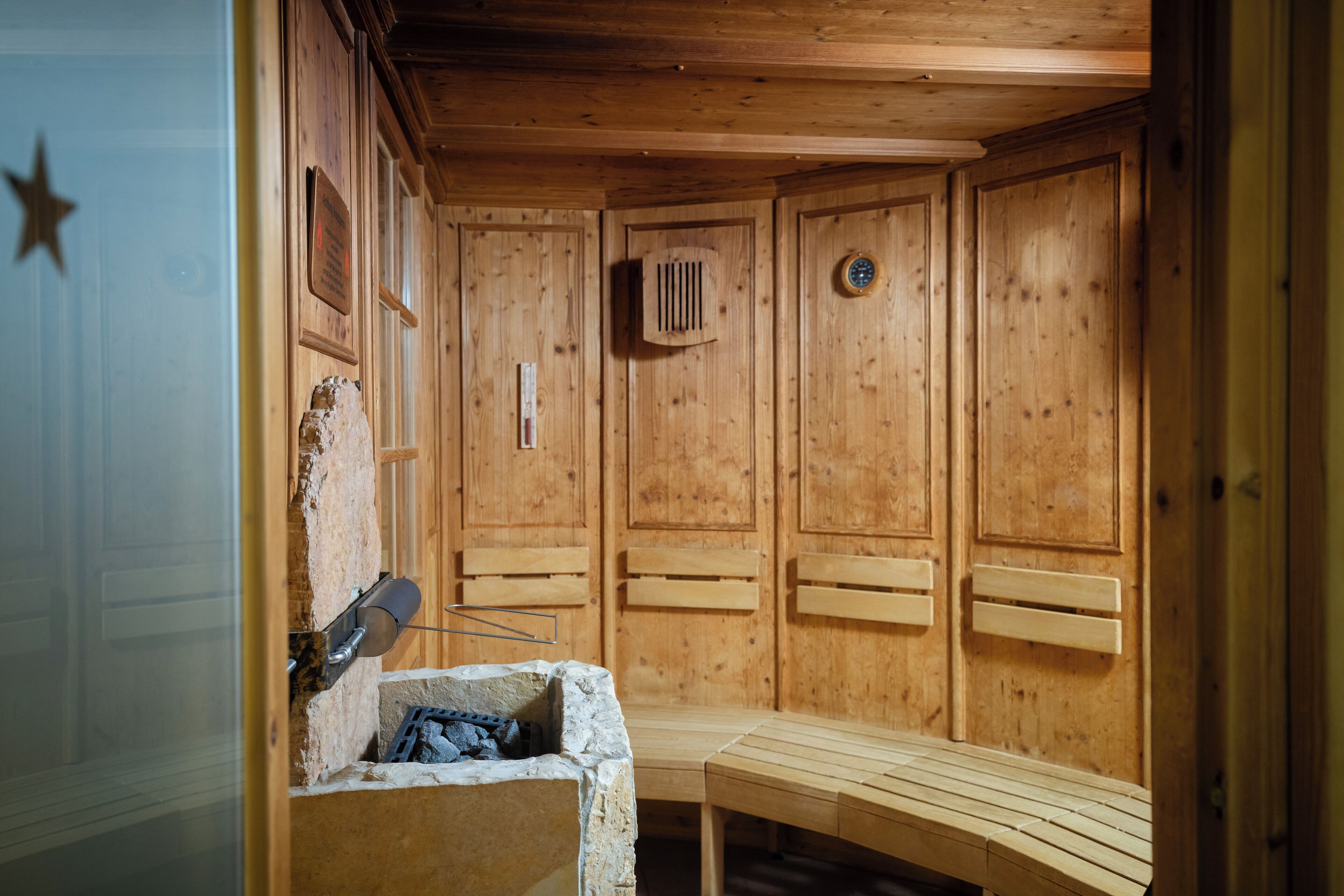 A sauna room with wooden walls, benches, and a bench with a towel.