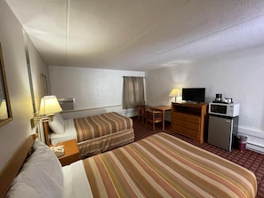 A hotel room with two beds, a desk, a television, a refrigerator, and a microwave. - The Autumn Inn (Bennington)